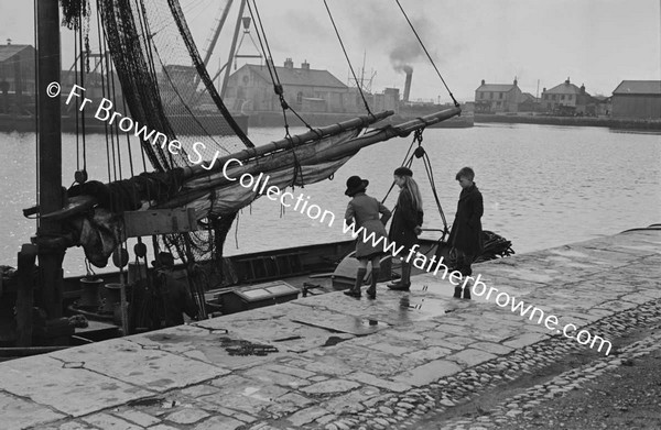 CHILDREN LOOKING AT BOAT IN HARBOUR